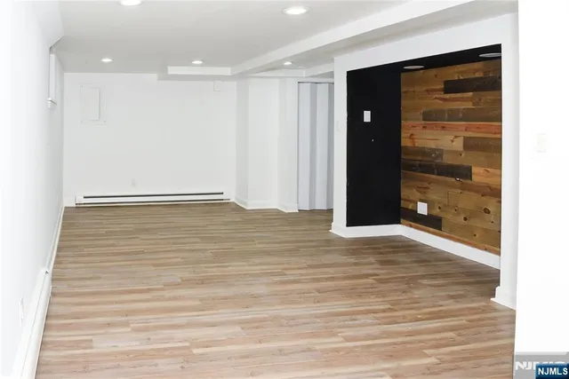 a view of an empty room with wooden floor