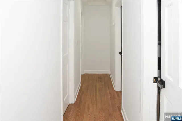 a view of a hallway with wooden floor