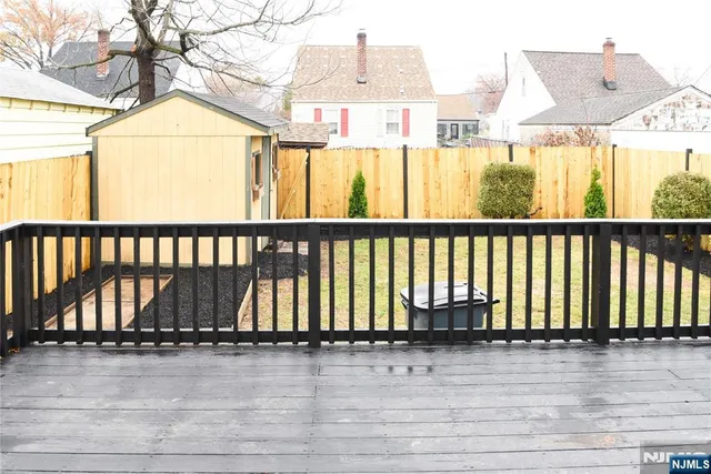 a view of a balcony with wooden floor and fence