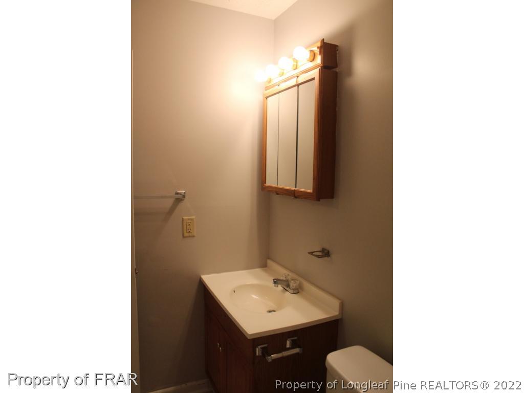 6490 Green Meadow Road Fayetteville, NC 28304 - Photo 13 of 22 a bathroom with a toilet sink and mirror