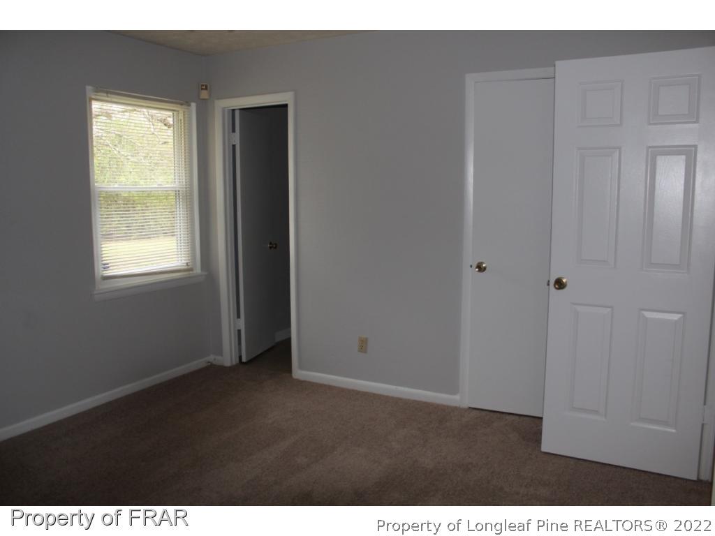 6490 Green Meadow Road Fayetteville, NC 28304 - Photo 17 of 22 a view of an empty room with closet and a window