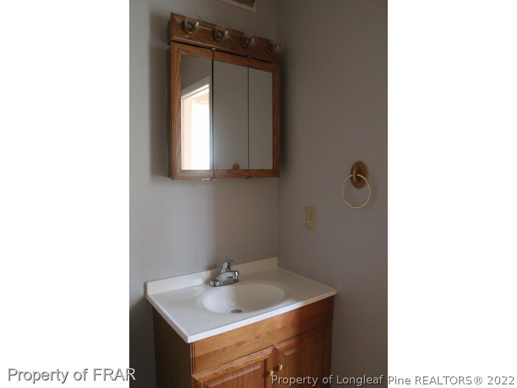 6490 Green Meadow Road Fayetteville, NC 28304 - Photo 18 of 22 a bathroom with a sink and a mirror