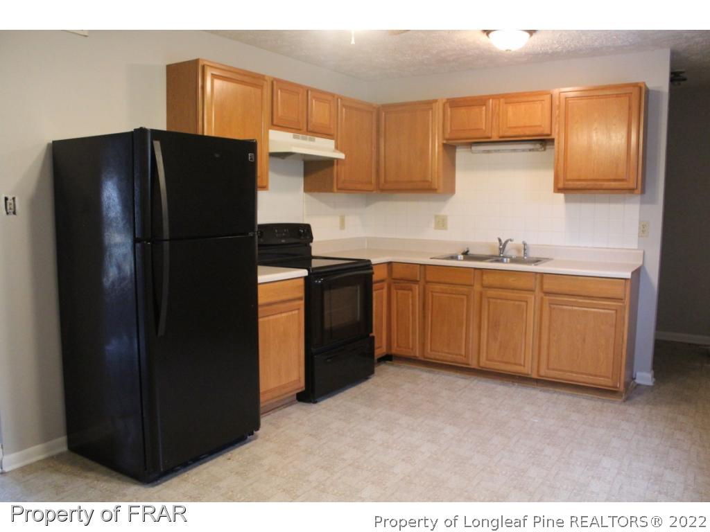 6490 Green Meadow Road Fayetteville, NC 28304 - Photo 5 of 22 a kitchen with stainless steel appliances granite countertop a refrigerator and a sink