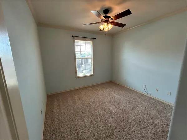 an empty room with fan and entrance