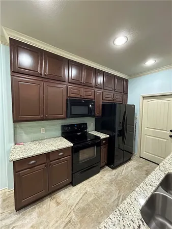 a kitchen with stainless steel appliances granite countertop a refrigerator and a stove