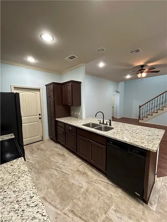 a large kitchen with kitchen island granite countertop a large counter top stainless steel appliances and cabinets