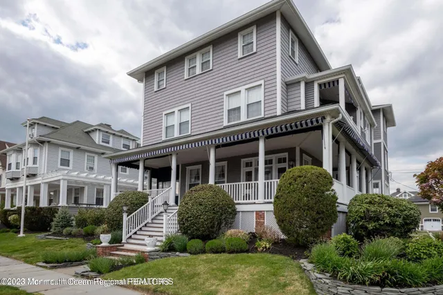 a front view of a house with a yard and plants