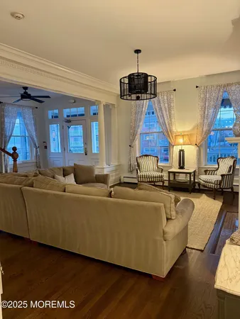 a living room with furniture a wooden floor and chandelier
