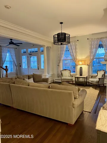 a living room with furniture a wooden floor and chandelier