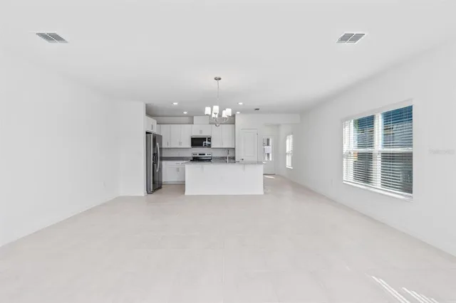 a view of a kitchen with refrigerator and window