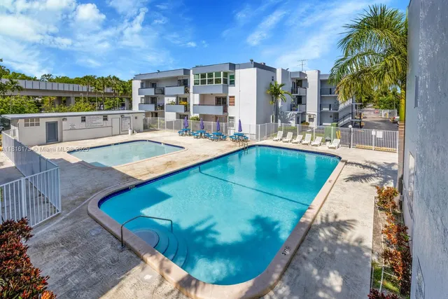 a view of a swimming pool with a patio and a yard