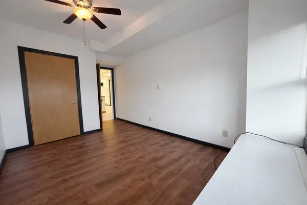 a view of an empty room with window and wooden floor