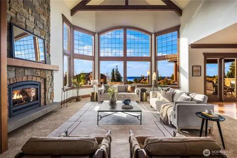 a living room with furniture a floor to ceiling window and a fireplace