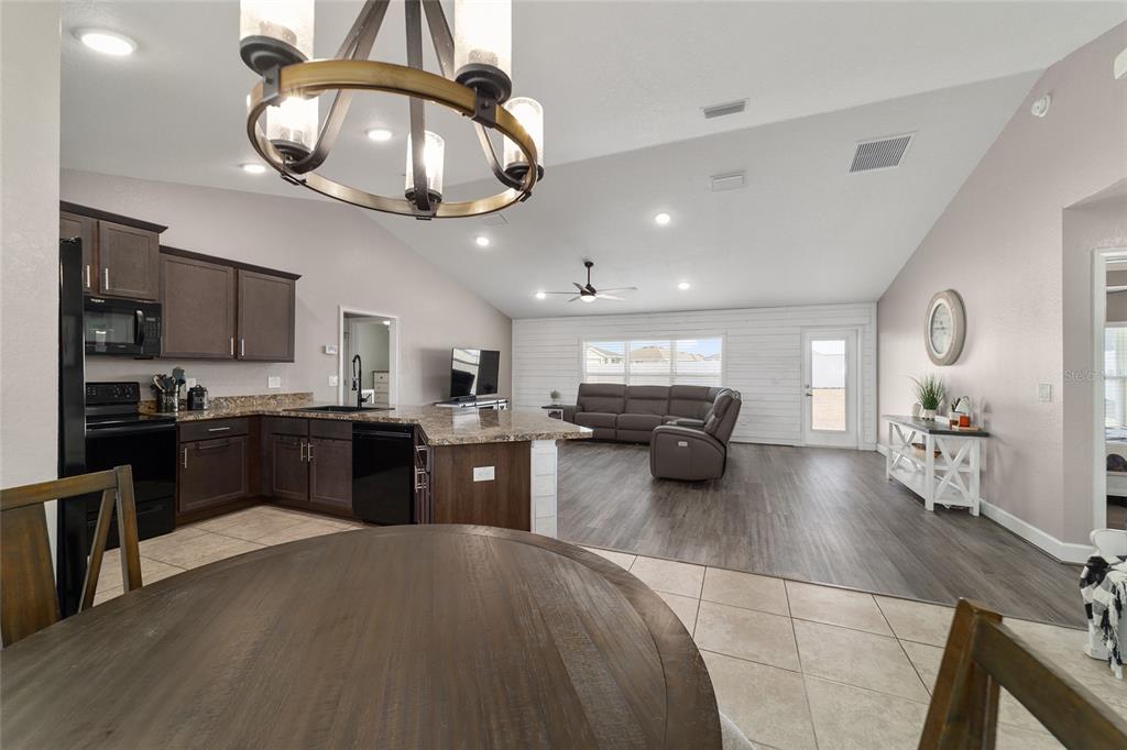 9155 Southeast 47th Court Road Ocala, FL 34480 - Photo 13 of 47 a kitchen with stainless steel appliances kitchen island granite countertop a refrigerator a stove microwave and a sink with large countertops