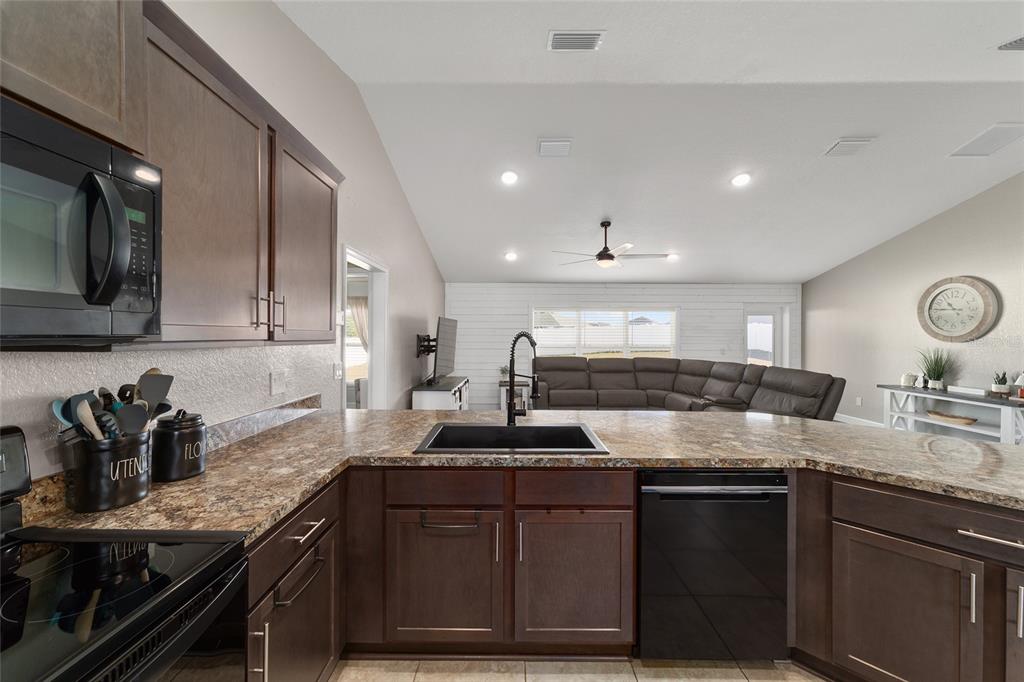 9155 Southeast 47th Court Road Ocala, FL 34480 - Photo 17 of 47 a kitchen with granite countertop a sink stainless steel appliances and cabinets