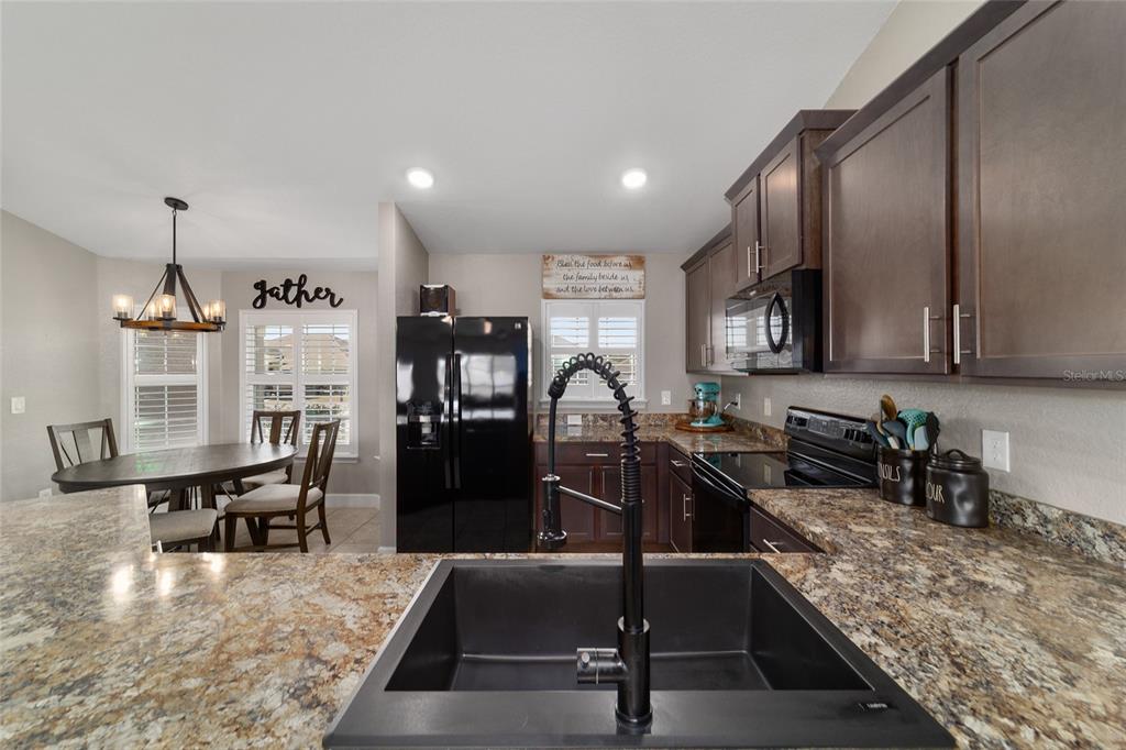 9155 Southeast 47th Court Road Ocala, FL 34480 - Photo 19 of 47 a kitchen with a table chairs sink and refrigerator