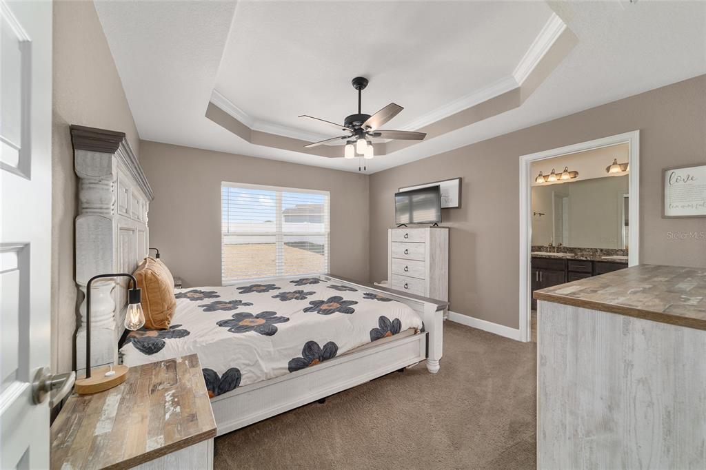 9155 Southeast 47th Court Road Ocala, FL 34480 - Photo 24 of 47 a bedroom with a bed and a large mirror on the dresser