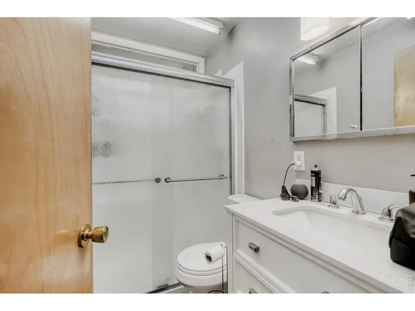 a bathroom with a sink toilet a mirror and shower