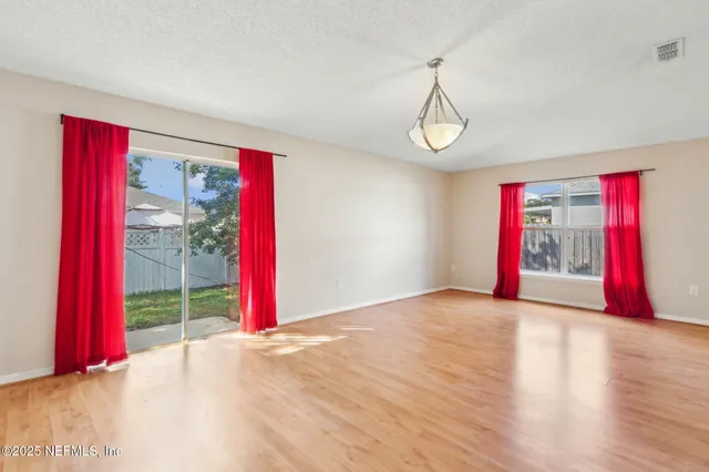 a view of a room with wooden floor and windows
