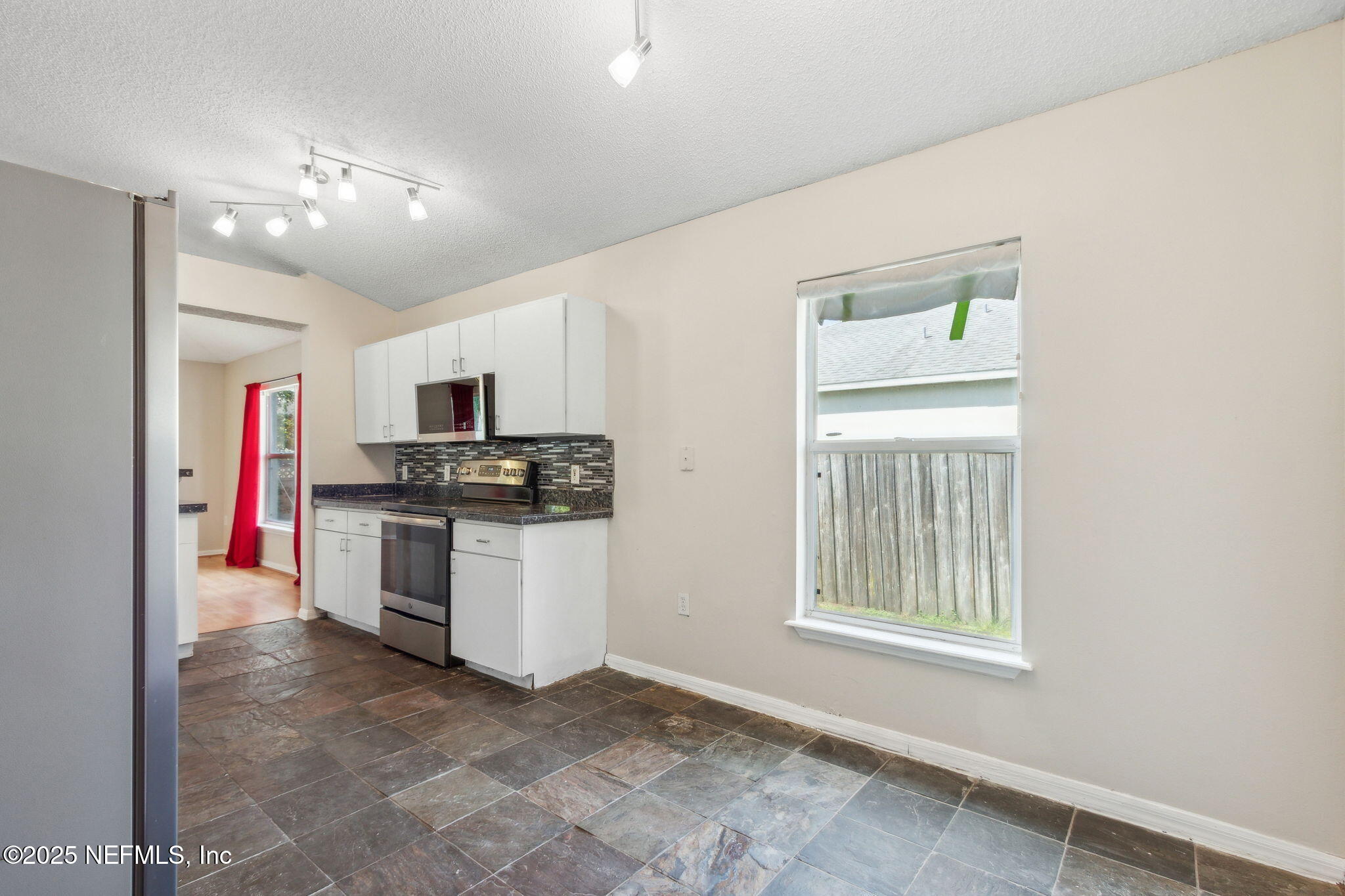 7364 Edenfield Park Road Jacksonville, FL 32244 - Photo 12 of 31 a kitchen with stainless steel appliances kitchen island granite countertop a refrigerator and a stove top oven