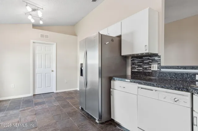 a kitchen with stainless steel appliances granite countertop a refrigerator and a stove