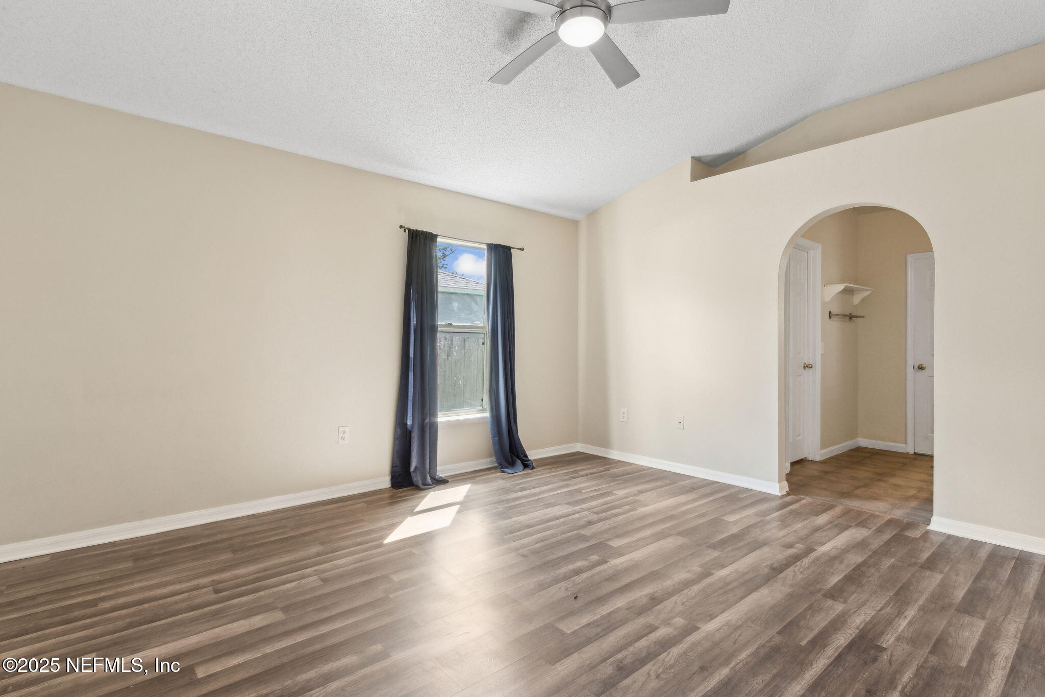 7364 Edenfield Park Road Jacksonville, FL 32244 - Photo 19 of 31 an empty room with wooden floor fan and windows
