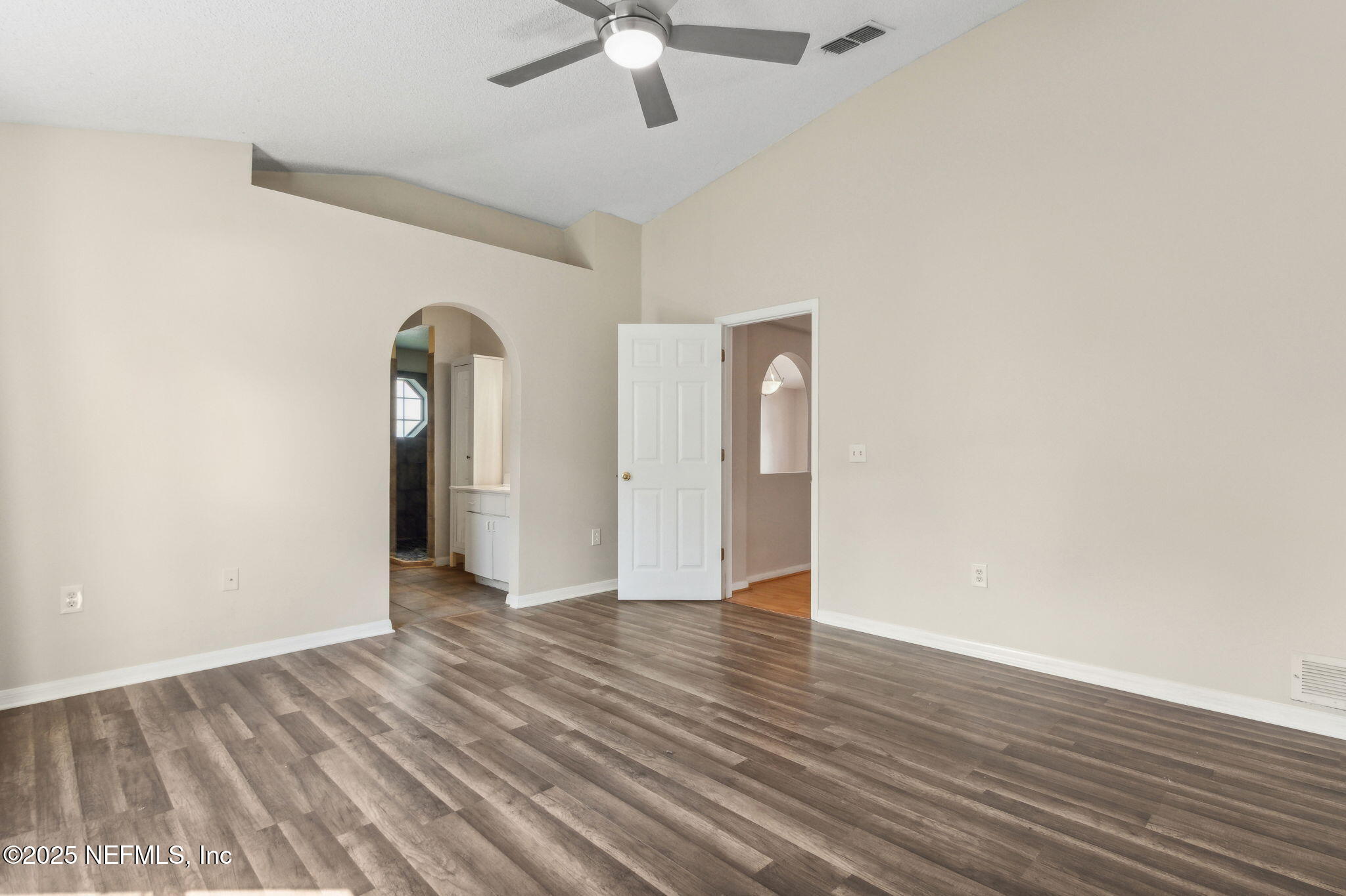 7364 Edenfield Park Road Jacksonville, FL 32244 - Photo 20 of 31 an empty room with wooden floor chandelier fan and windows