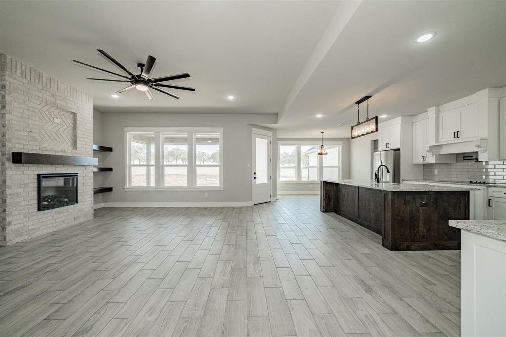 2017 Swallowtail Court Poolville, TX 76487 - Photo 11 of 32 a view of kitchen with microwave a stove and wooden floors