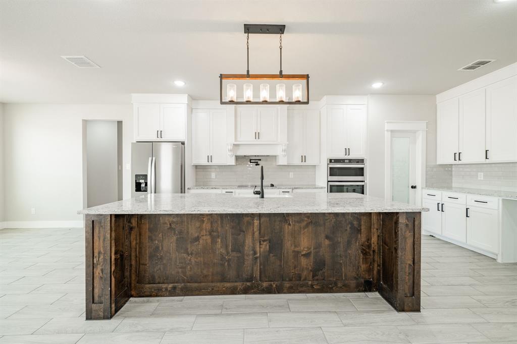 2017 Swallowtail Court Poolville, TX 76487 - Photo 13 of 32 a kitchen with stainless steel appliances a sink and cabinets