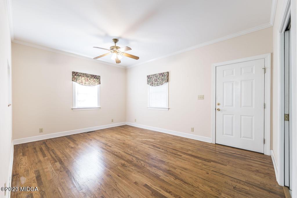 6375 Barfield Road Macon, GA 31216 - Photo 47 of 60 an empty room with wooden floor ceiling fan and windows