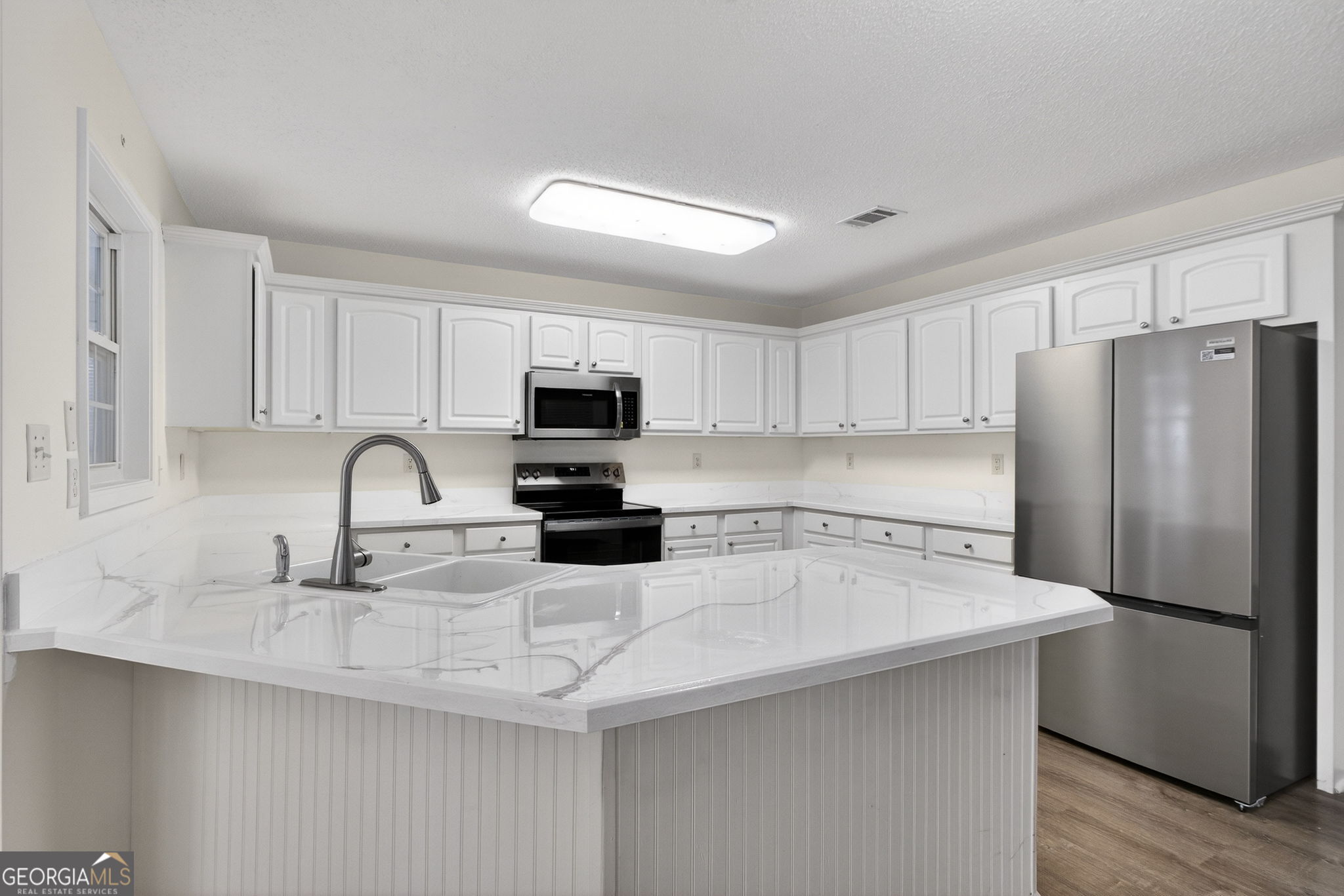 108 Whippoorwill Ridge Road Jackson, GA 30233 - Photo 13 of 39 a kitchen with refrigerator a sink a stove a microwave and cabinets