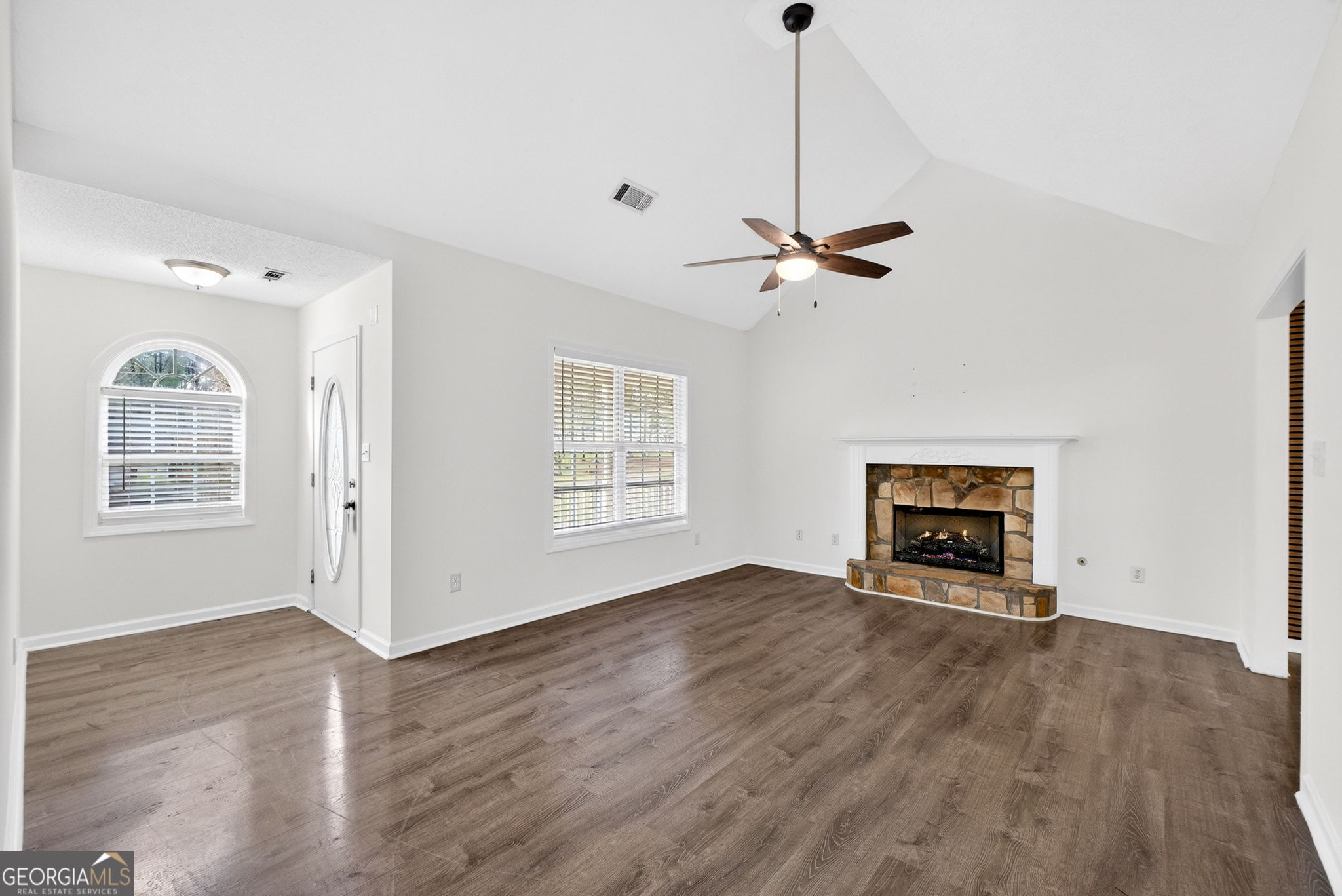 108 Whippoorwill Ridge Road Jackson, GA 30233 - Photo 8 of 39 an empty room with wooden floor chandelier fan and windows