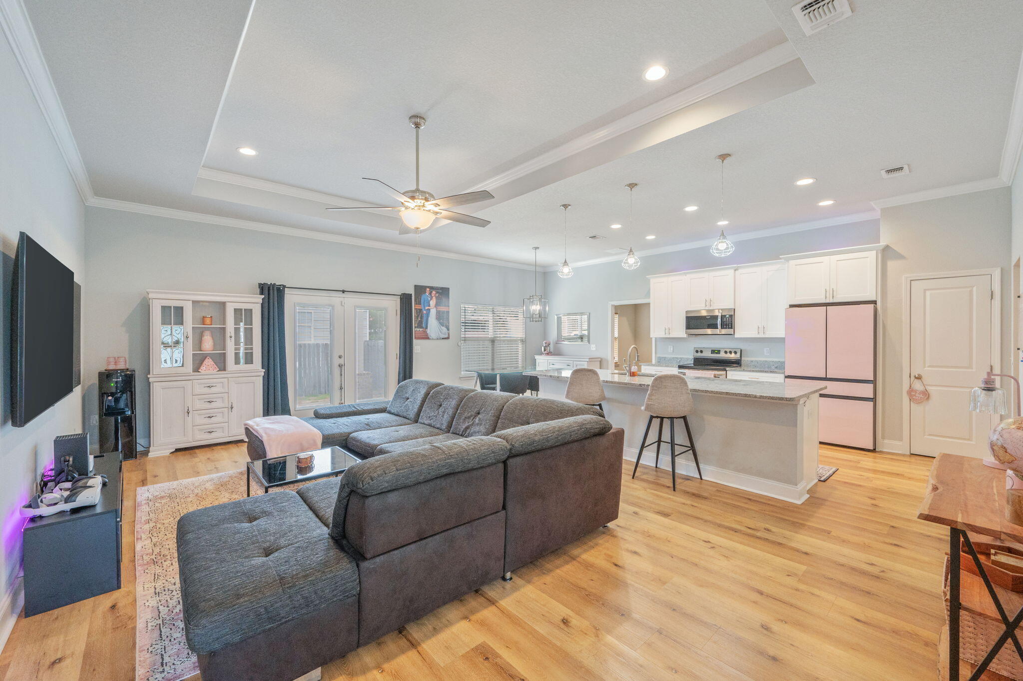 a living room with stainless steel appliances kitchen island furniture and a flat screen tv