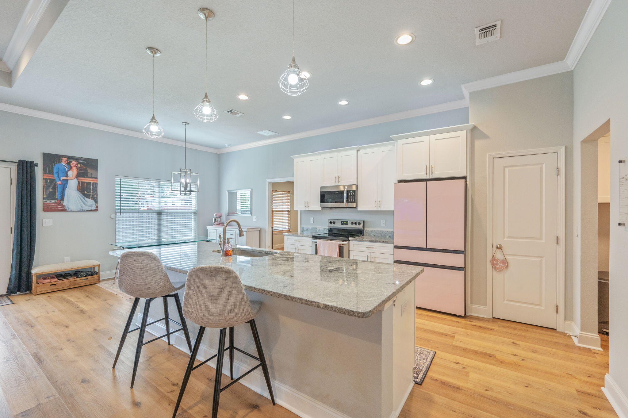 899 Al Hammett Road Mary Esther, FL 32569 - Photo 8 of 34 a kitchen with stainless steel appliances kitchen island granite countertop a refrigerator a stove a sink a dining table and chairs with wooden floor