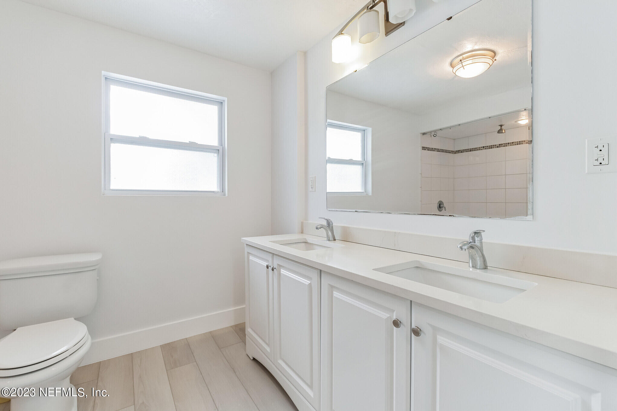 3307 Trout River Boulevard Jacksonville, FL 32208 - Photo 22 of 37 a bathroom with a granite countertop sink a toilet and a mirror