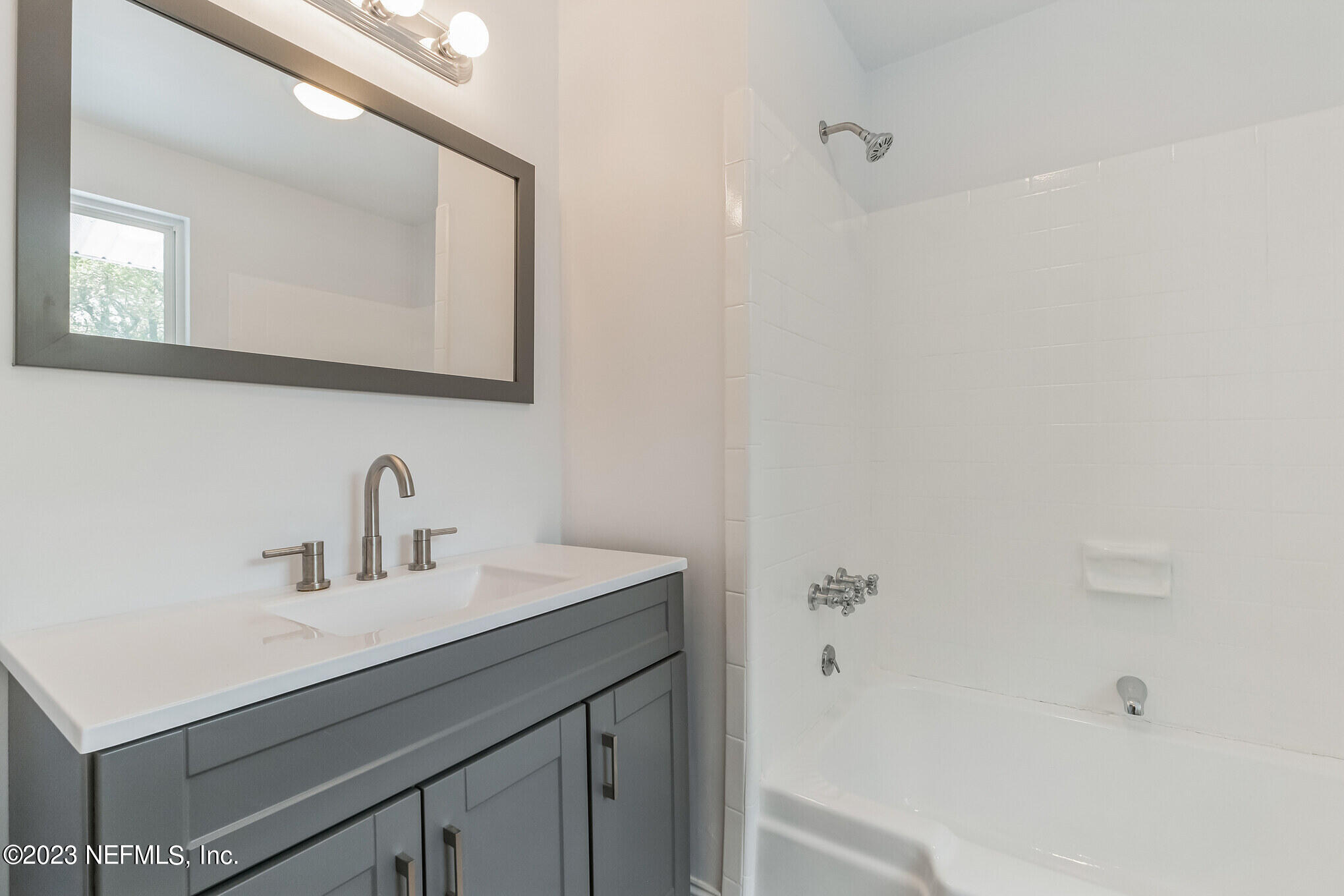 3307 Trout River Boulevard Jacksonville, FL 32208 - Photo 29 of 37 a bathroom with a sink a mirror and a bathtub