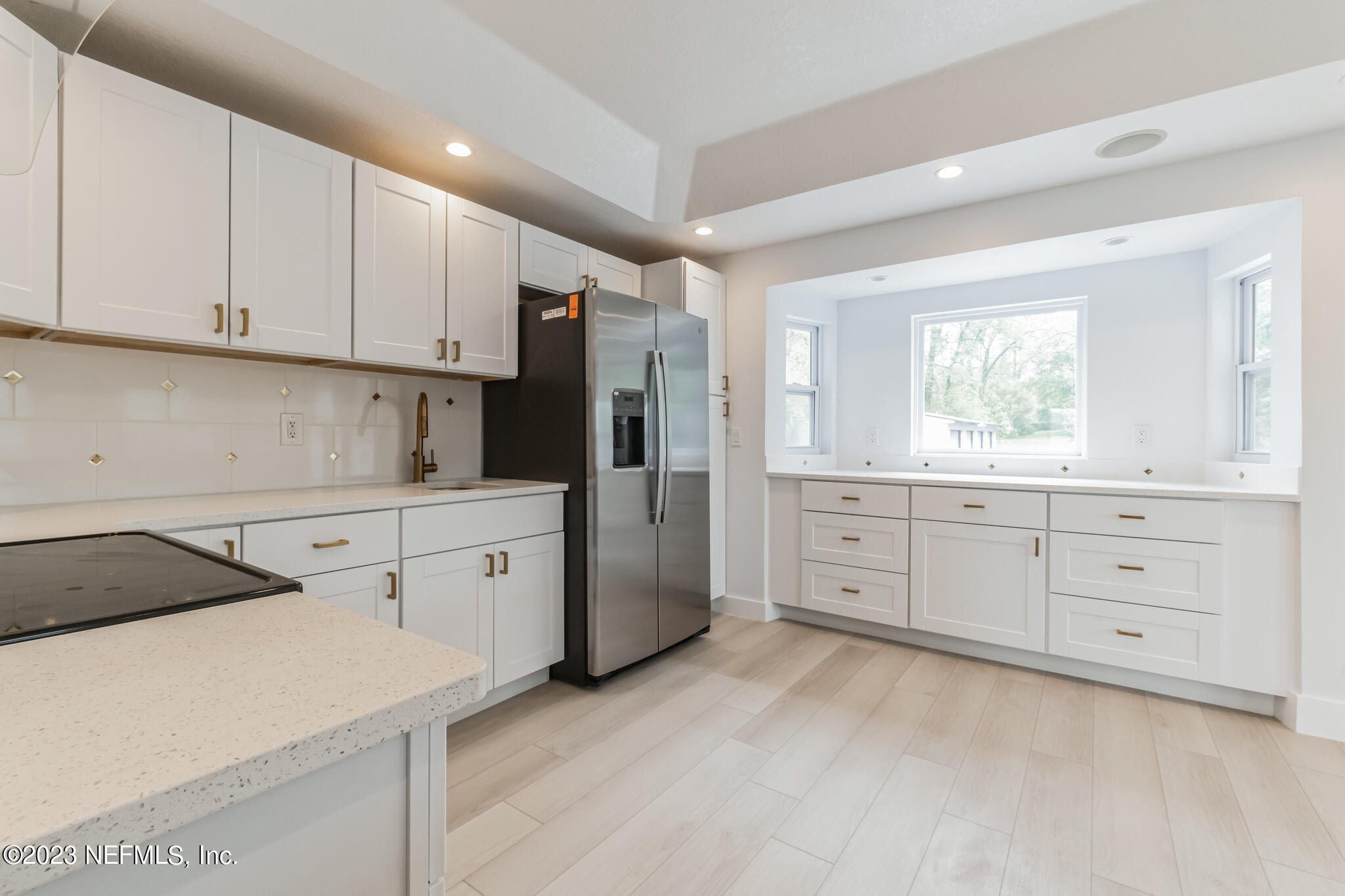 3307 Trout River Boulevard Jacksonville, FL 32208 - Photo 6 of 37 a kitchen with white cabinets and white appliances