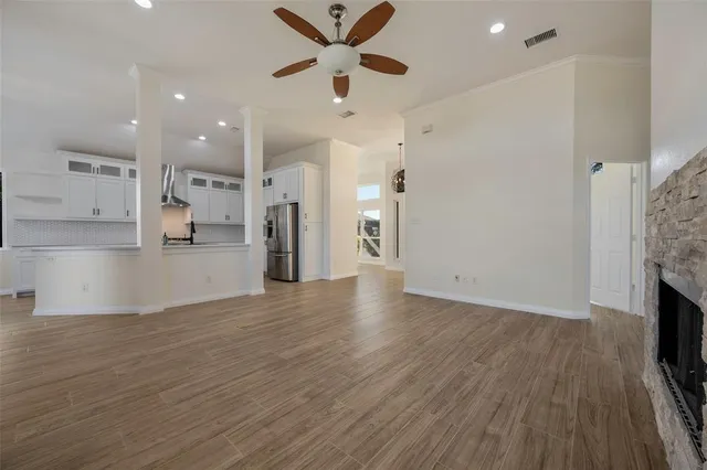 a view of a living room a flat screen tv and a ceiling fan