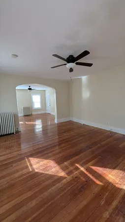 a view of a room with wooden floor and a ceiling fan