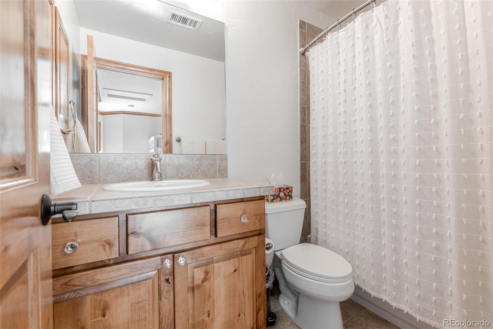 2515 South Fillmore Street Denver, CO 80210 - Photo 25 of 39 a bathroom with a toilet sink and mirror
