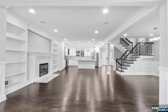 a view of a room with wooden floors and kitchen view