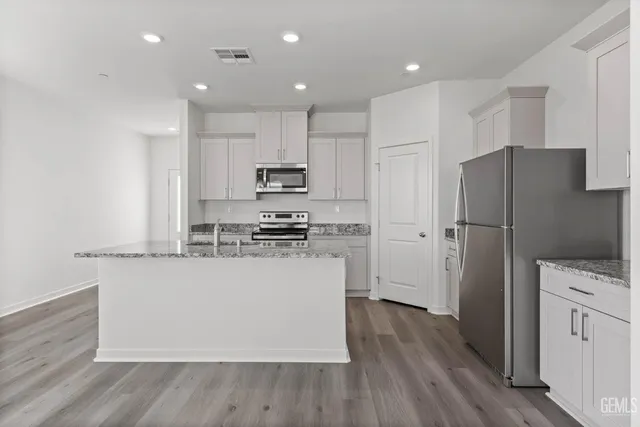 a kitchen with stainless steel appliances a refrigerator and a stove top oven