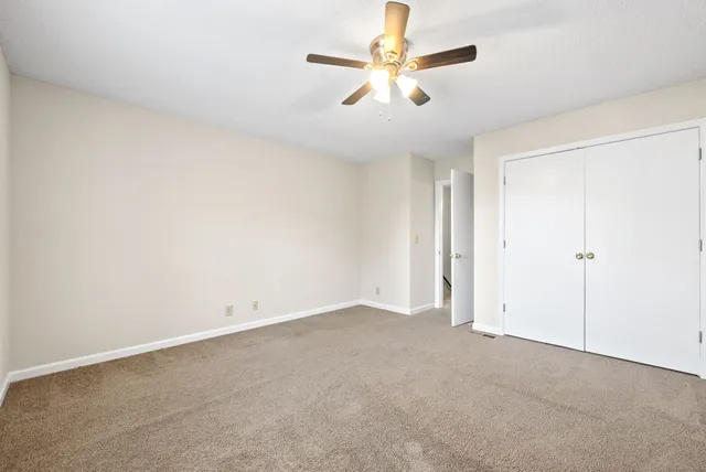 an empty room with chandelier fan