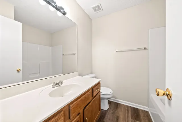 a bathroom with a sink toilet and mirror