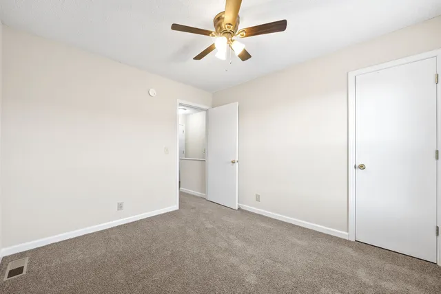 an empty room with chandelier fan