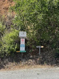 a sign board with a bench and trees