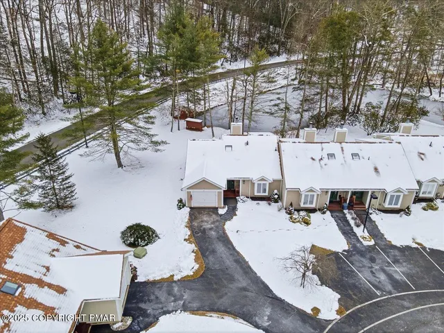an aerial view of a house with yard and trees