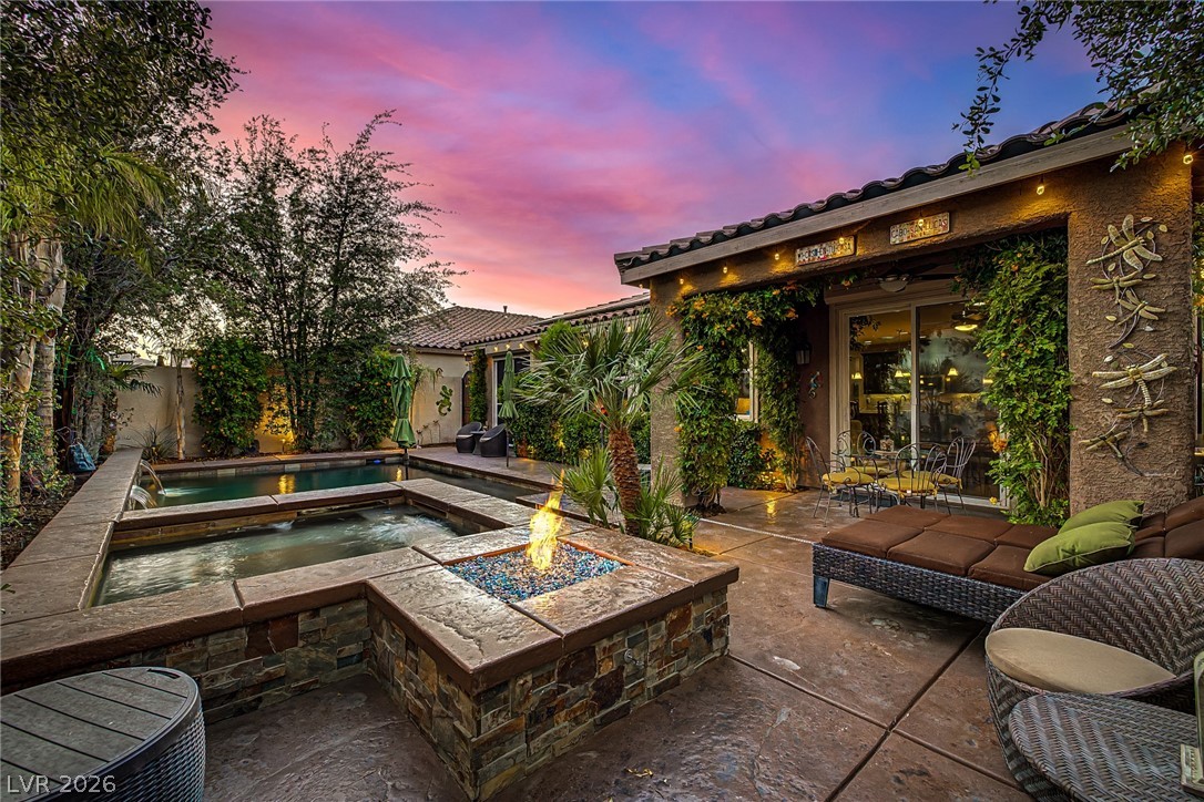 7415 Campbell Ranch Avenue Las Vegas, NV 89179 - Photo 43 of 52 An inviting backyard oasis under a vibrant sunset, complete with a sparkling pool, spa, and fire pit.