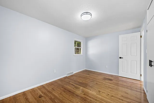 a view of a room with wooden floor and white walls