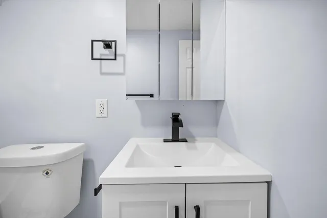 a bathroom with a sink a toilet and a mirror